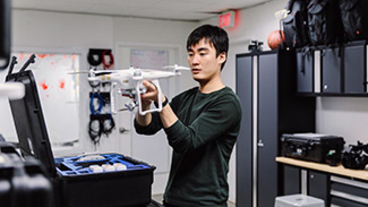 A student prepares a drone for shooting video.