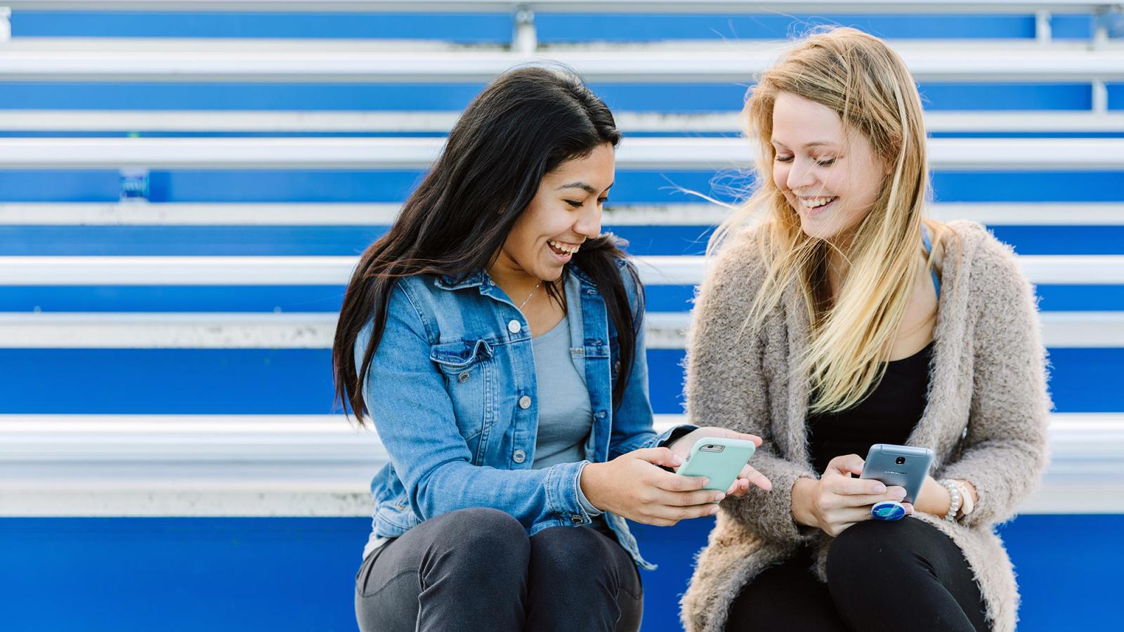 Two pace university students sitting on the football stadium bleachers