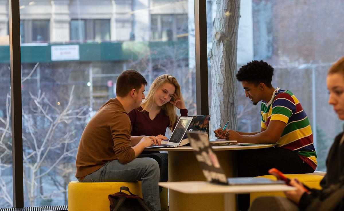 Students sitting at a desk studying together.