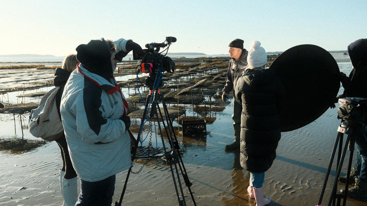 pace professor speaking to a film crew on the shore of the ocean