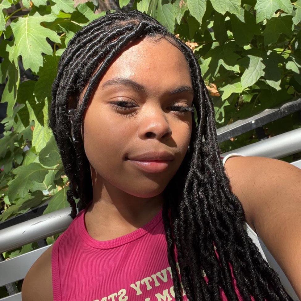 young woman in pink top looking at camera