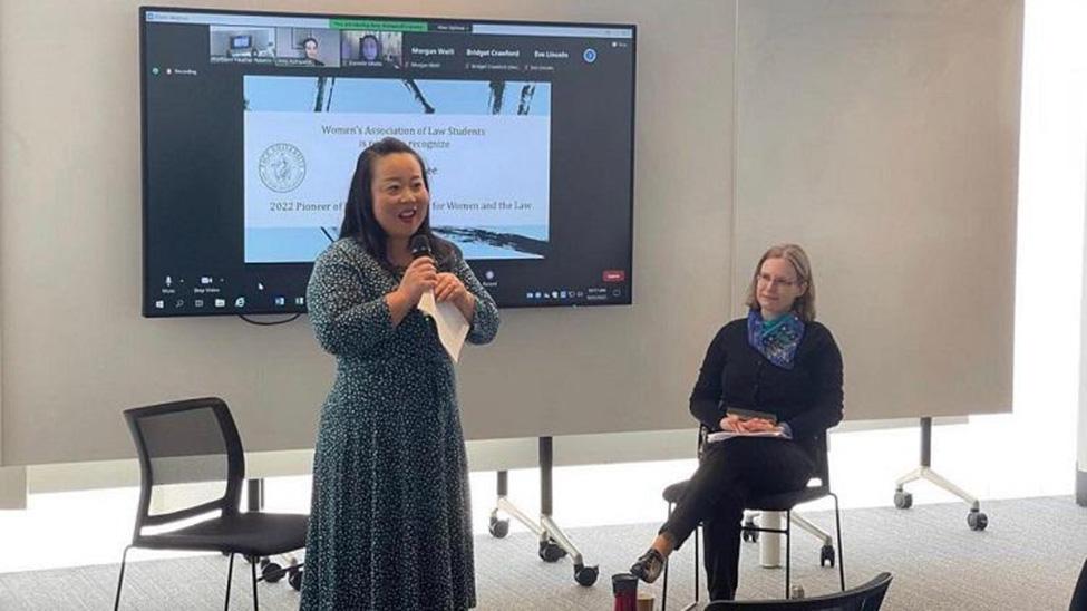 screenshot of Elizabeth Lee in Australia on Zoom accepting award and presenting remarks with moderator seated next to her