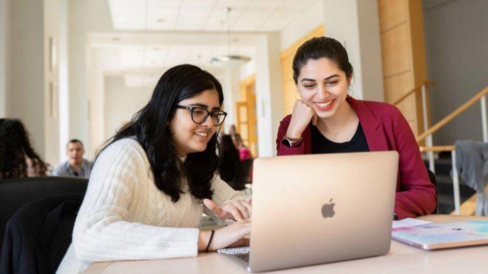 two female students at computer in Ottinger Hall of Elisabeth Haub School of Law