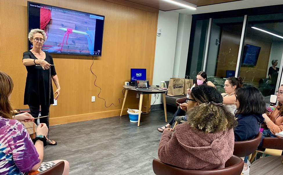 Jane Collins, PhD, teaches knitting to students from her residence hall 