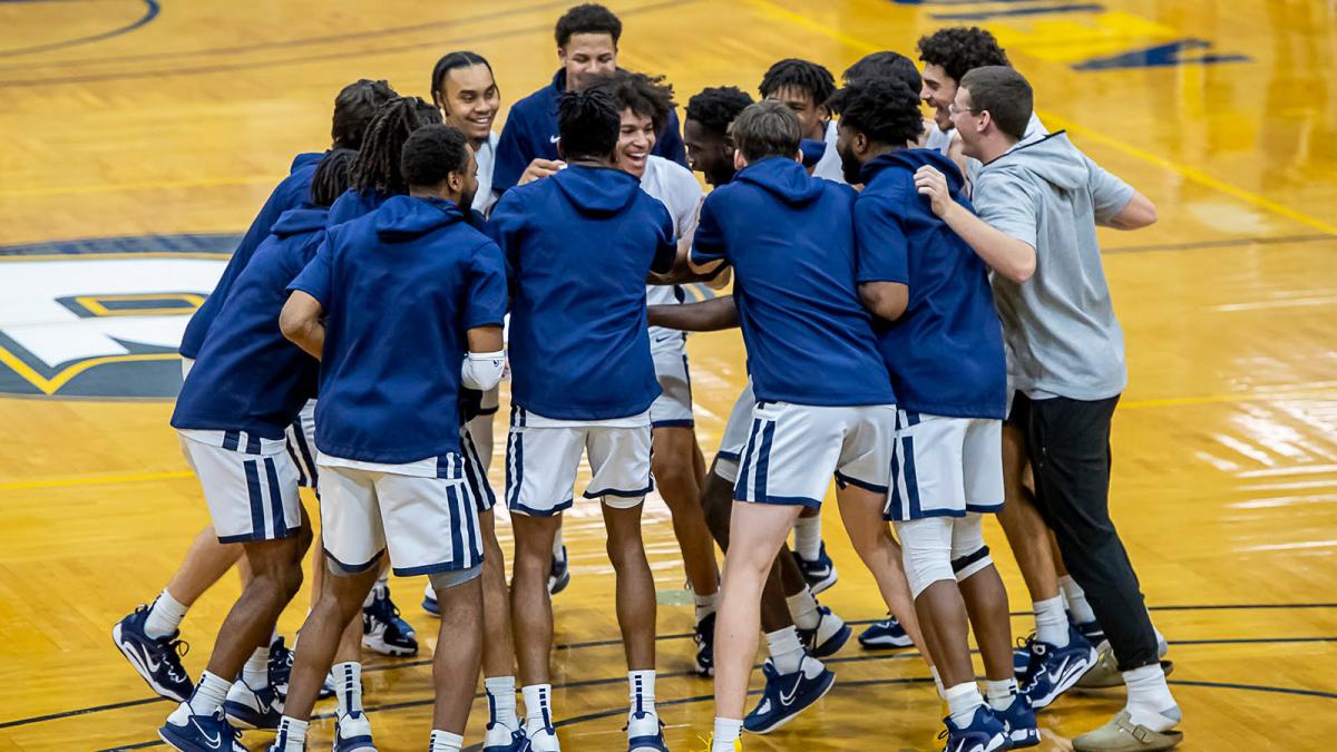 Pace University mens basketball team celebrating at mid court after a big win