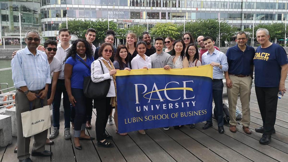 group of Pace students and professors holding a Pace banner 2019 field study to Singapore and Malaysia