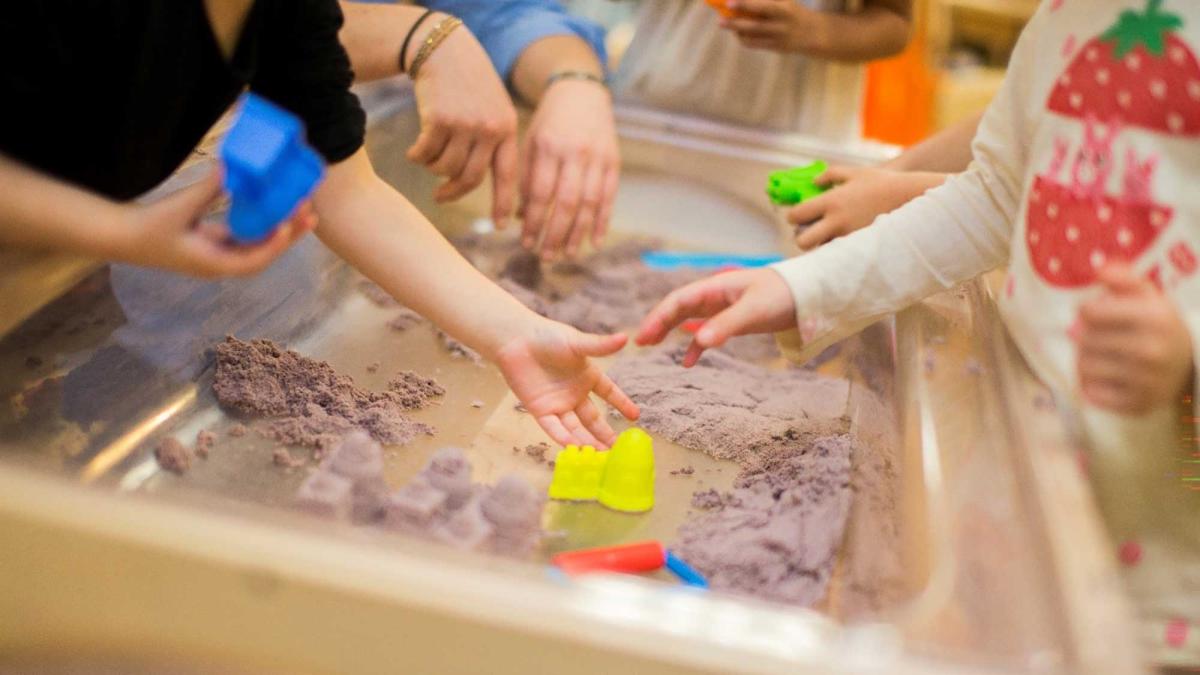 children playing with toys in a sandbox