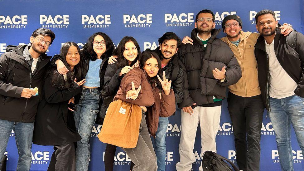 Seidenberg students posing together before a Pace step and repeat