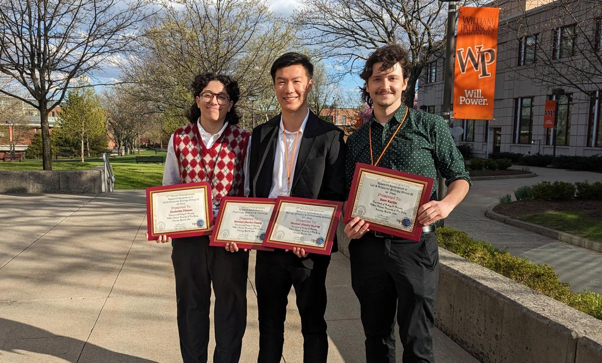 Three Pace University students standing together, each holding Biology awards earned for their work at the 17th Annual William Paterson University Undergraduate Research Symposium.