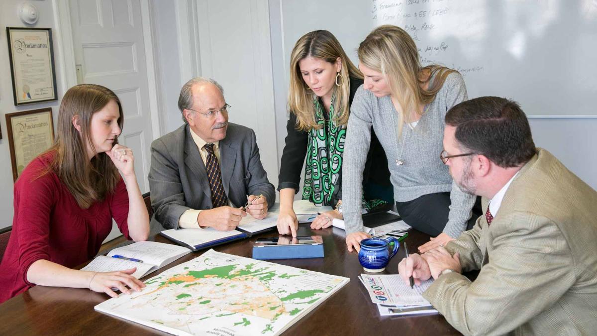 Meg Byerly Williams, John Nolon, Jennie Nolon-Blanchard, Tiffany Zezula, and gentleman in office looking at map, Land Use Law Center at Elisabeth Haub School of Law