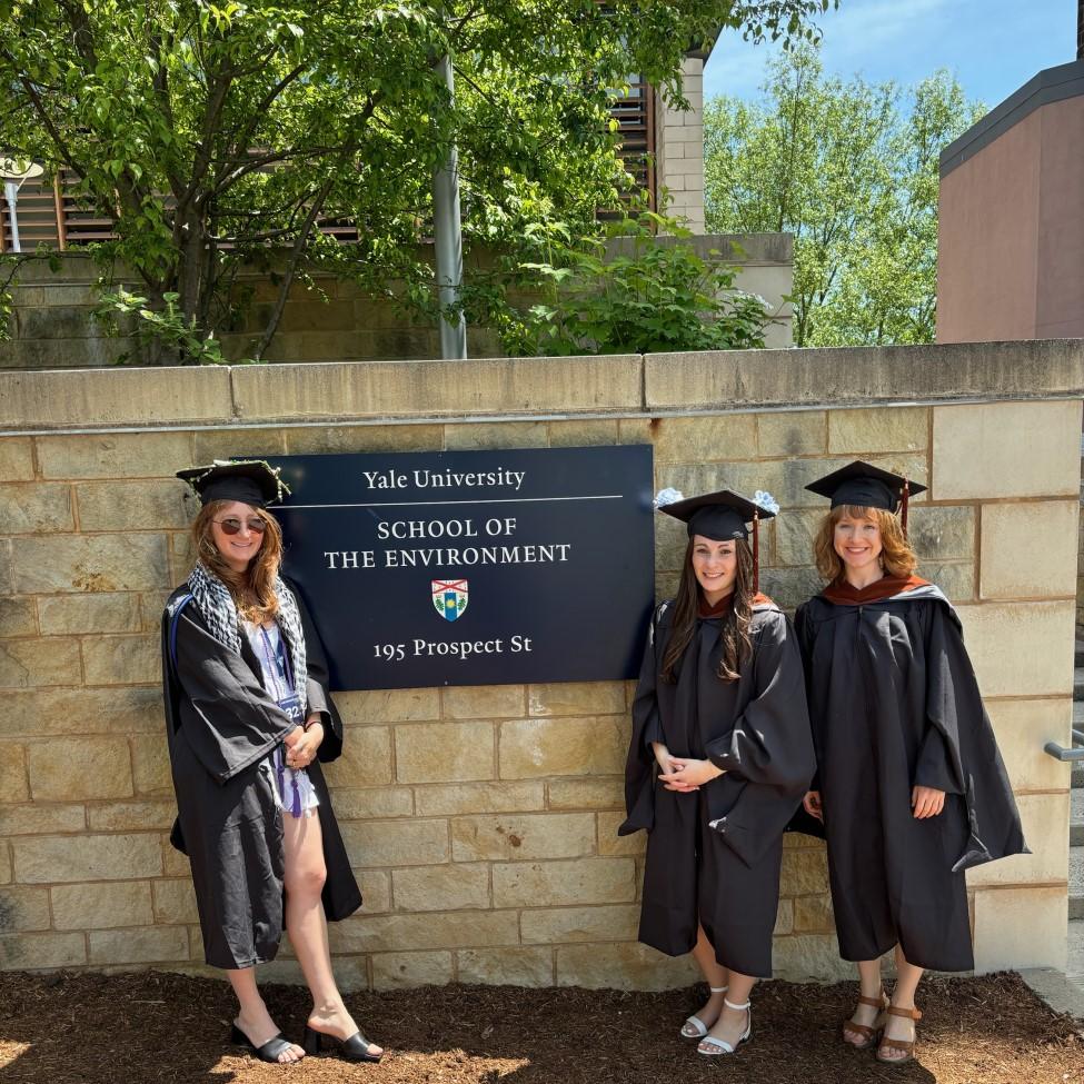 Three Elisabeth Haub School of Law joint degree students standing in front of a Yale School of the Environment sign