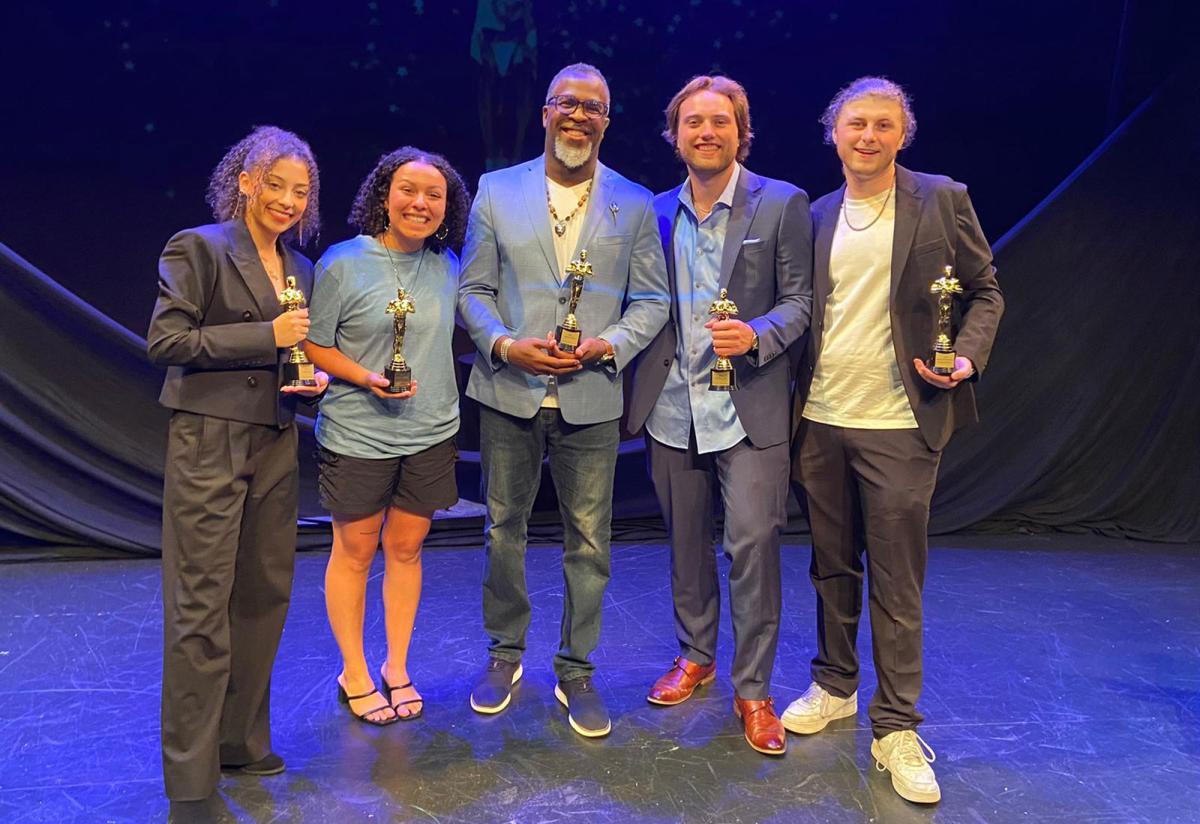 Pace University students Brooke Lyn Sicignano ’25, Ava Resco ’25, Adam Scott ’25, and Gannon Ripchik ’25 stand with Media, Communications, and Visual Arts professor Akil DuPont on stage