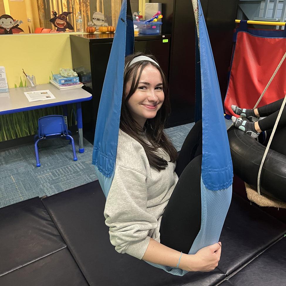 2025 Occupational Therapy student in a blue hammock swing.