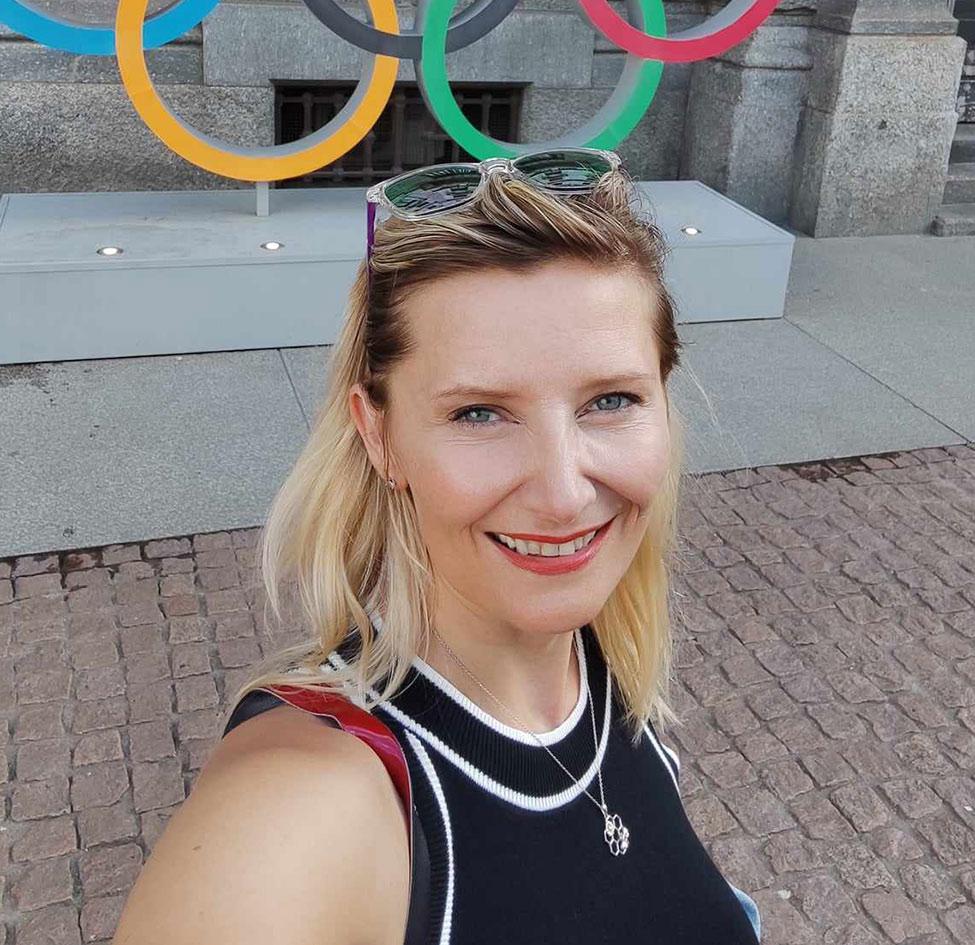 Pace University Associate Professor of Economics Veronika Dolar, PhD, with Olympic rings in the background.