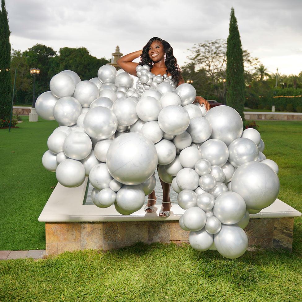 A model wears an intricate dress made of silver balloons designed by a Pace University student.