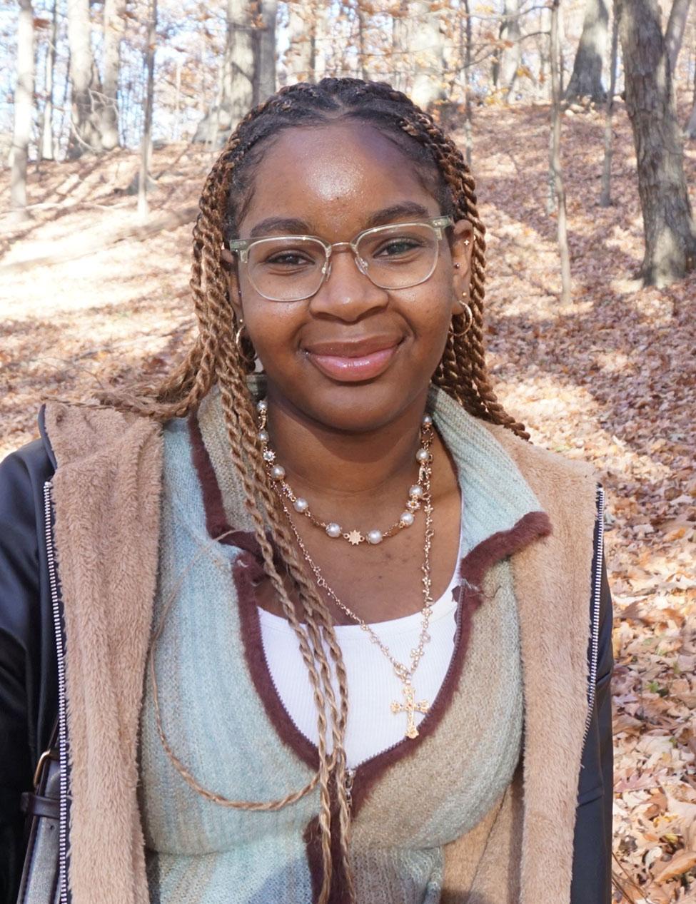 Pace University Economics student Shaniah James with leaves behind her