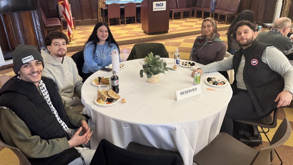 Elisabeth Haub School of Law at Pace University students sitting at a table at the Interfaith Celebration