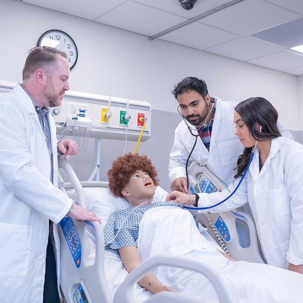 college of health professions professor Jason Slyer, DNP with nurse practitioner students in simulation lab.