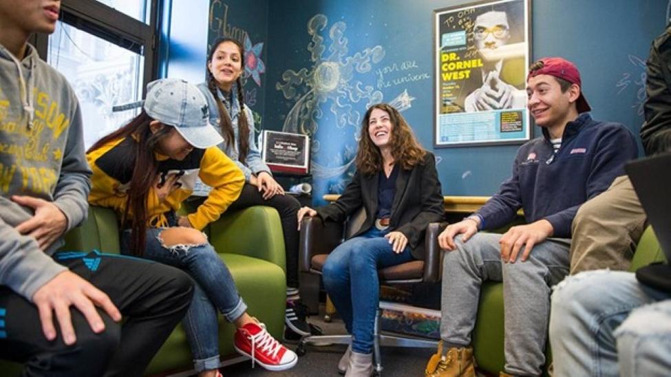 Pace University students in a circle talking and laughing.