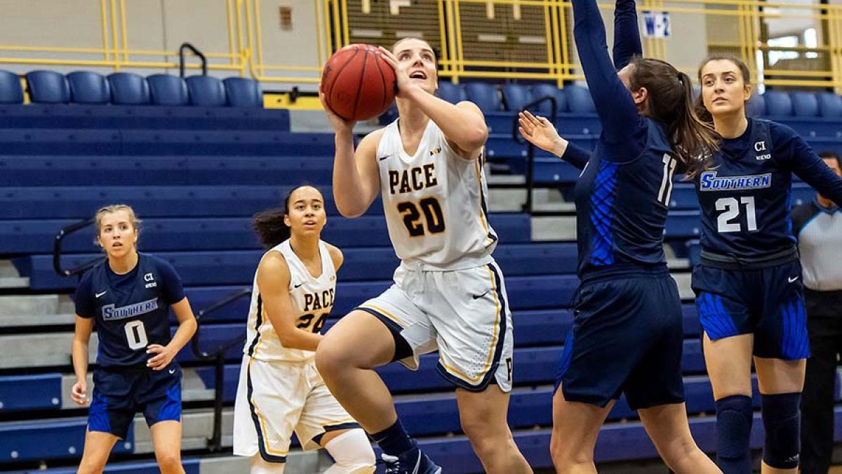 Women's basketball co-captain Lauren Schetter eluding defenders for a basket