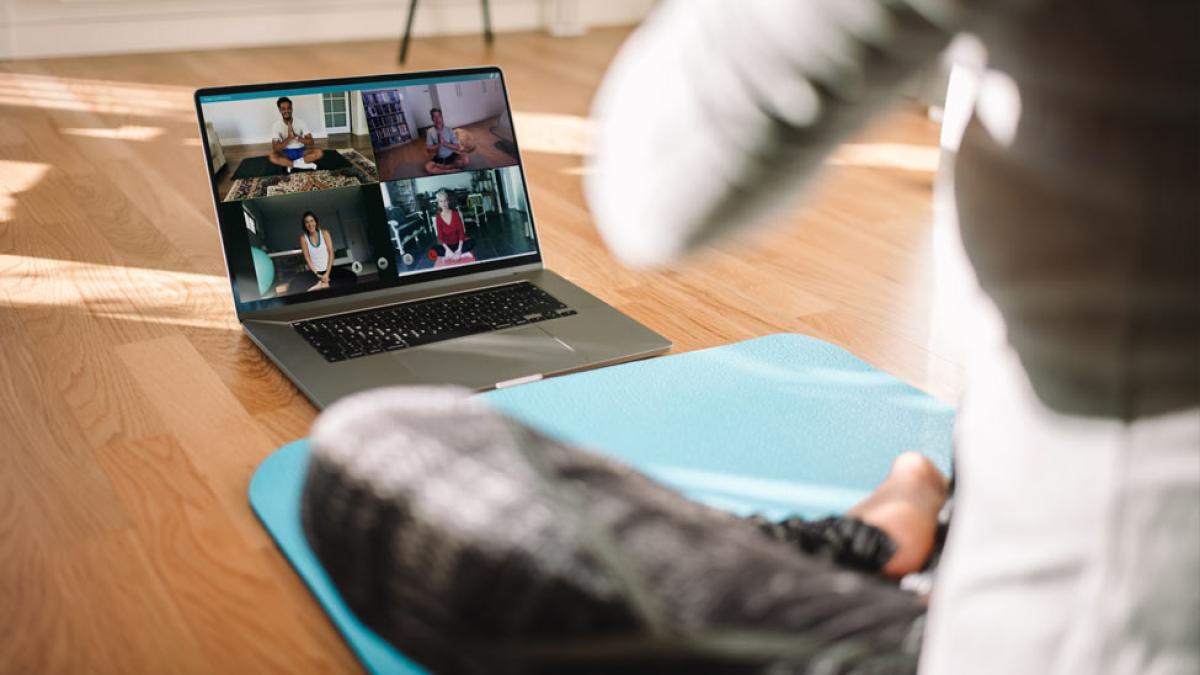 woman on floor doing yoga via zoom