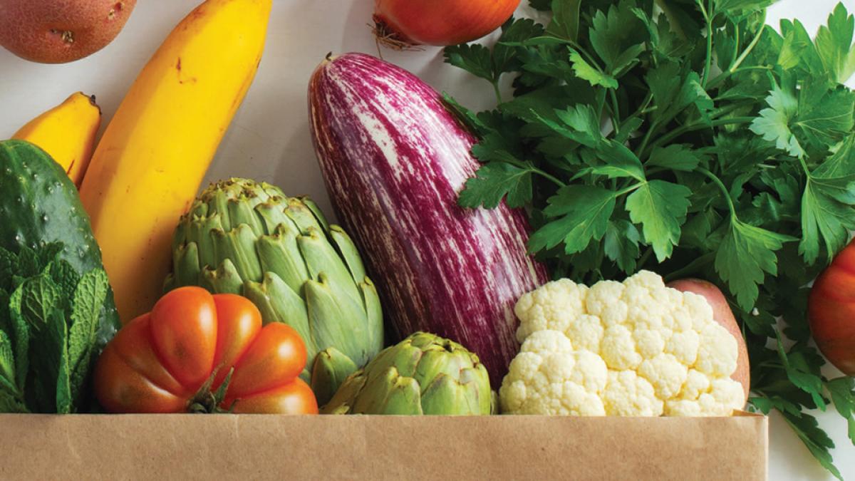 fresh produce spills out from a paper bag