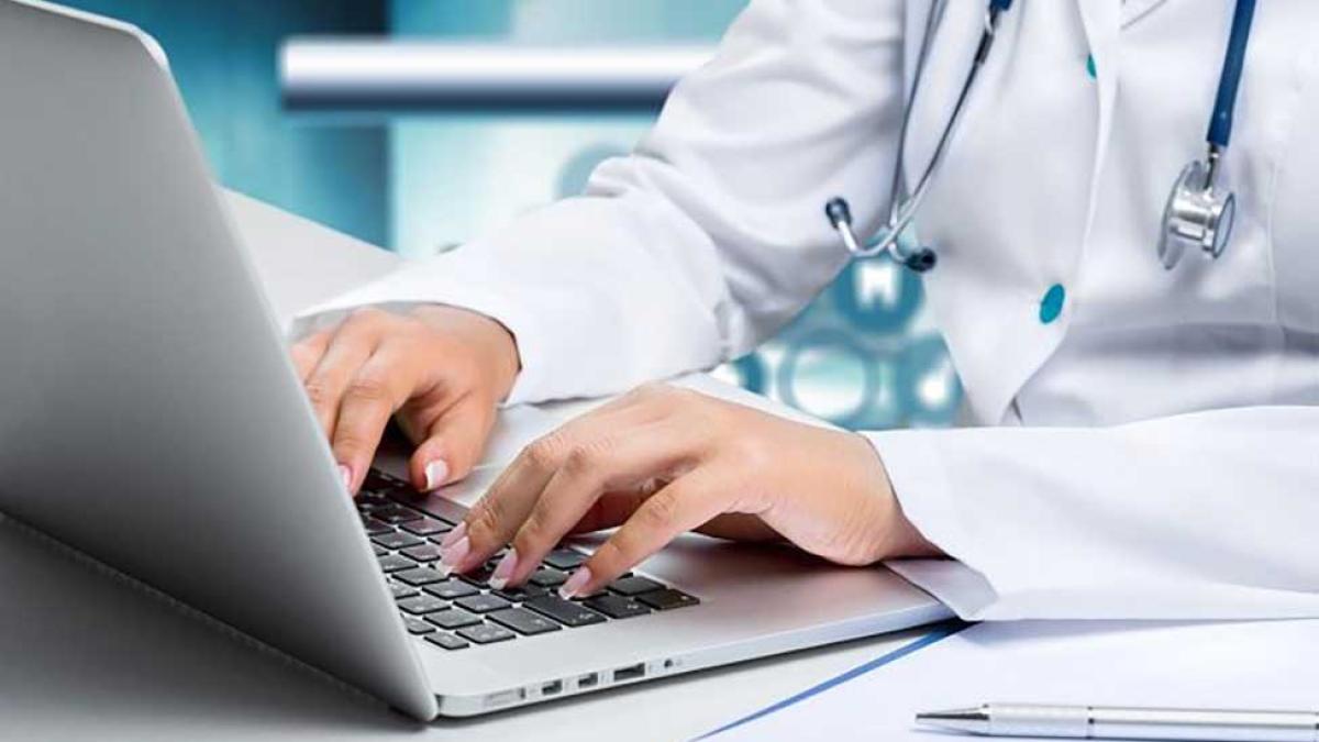 healthcare professional typing on laptop
