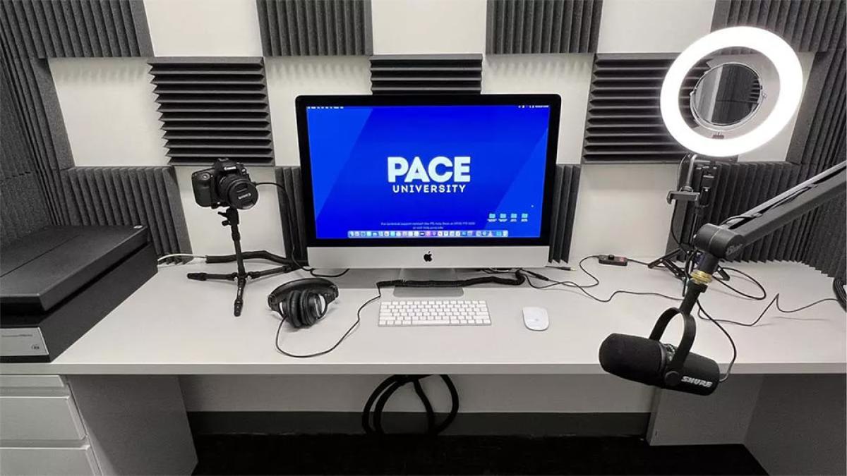 Photo of a computer screen with the Pace University logo, and other assorted computer hardware