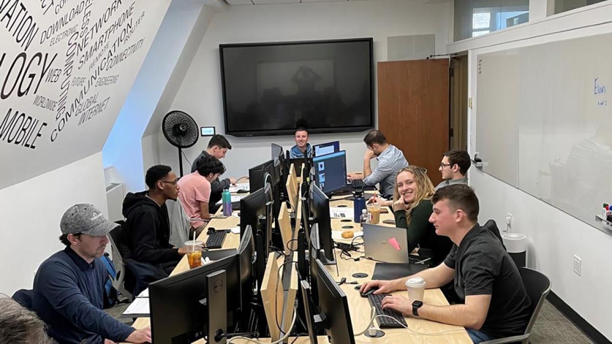 Seidenberg students gathered around long table in hacking competition