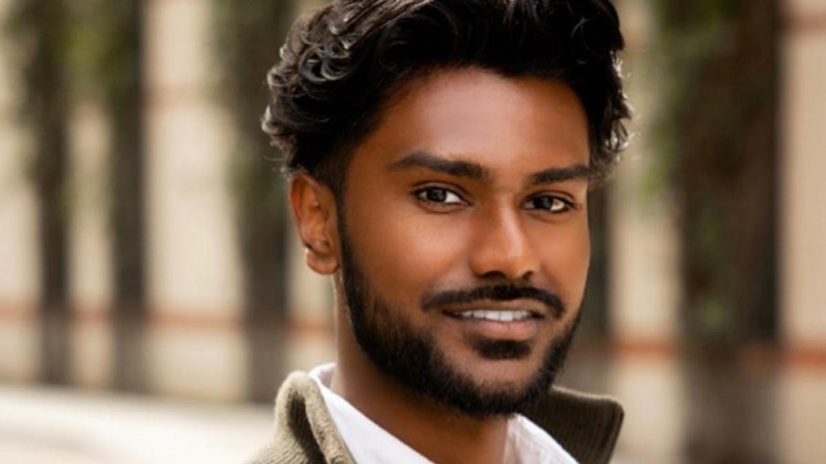 Portrait of Rudra Persuad, young chemistry major alum at Pace University wearing a dark zippered cardigan