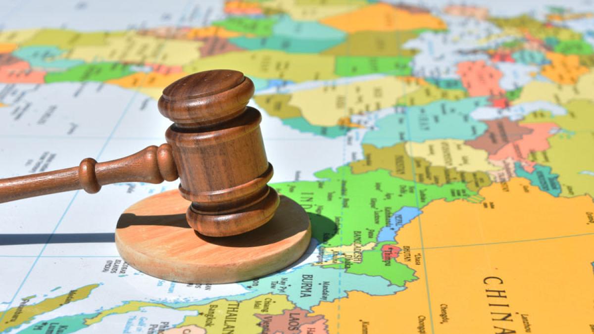 Judges gavel on top of a paper world map