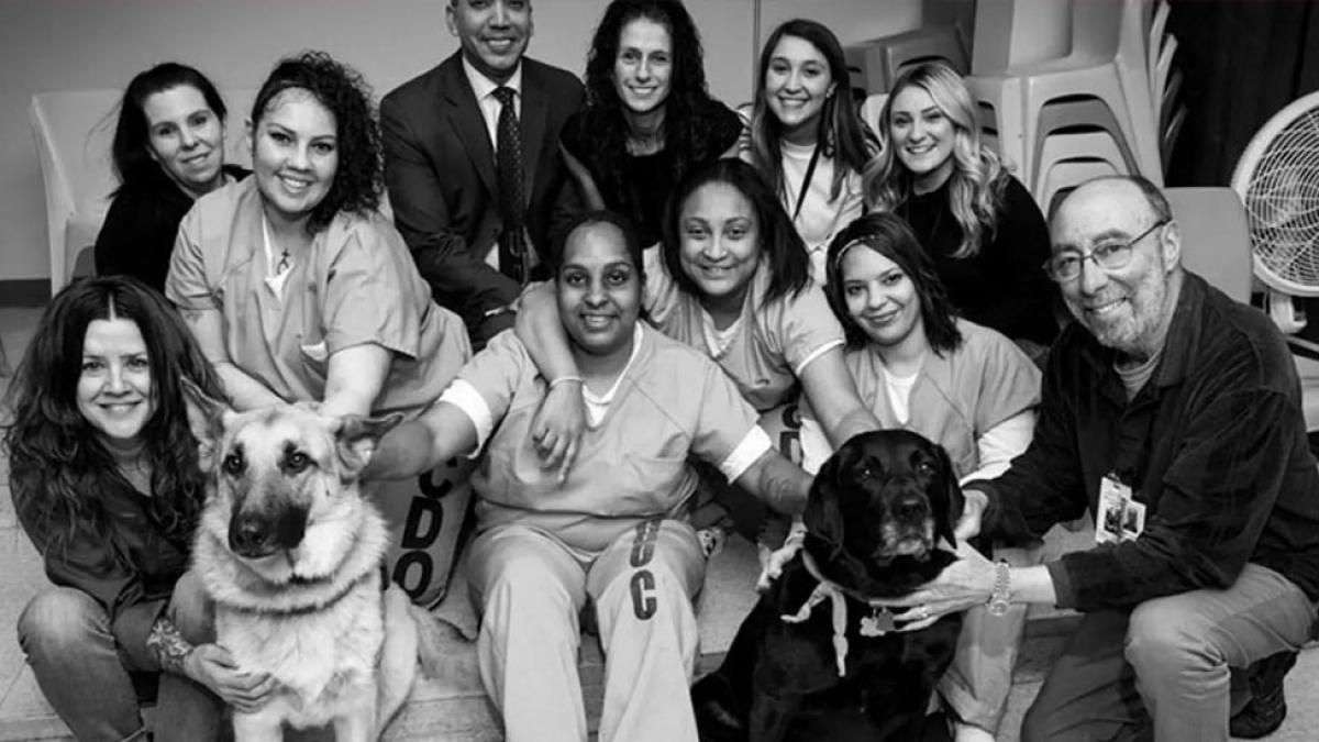 group photo of incarcerated women with their dogs. 