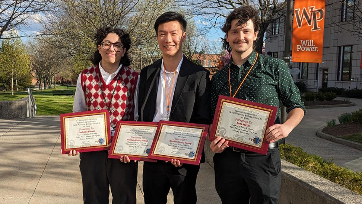 Three Pace University students standing together, each holding Biology awards earned for their work at the 17th Annual William Paterson University Undergraduate Research Symposium.