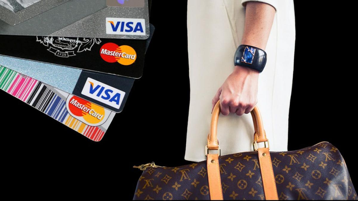 three credit cards and woman's arm holding shopping bag representing the idea of credit scores