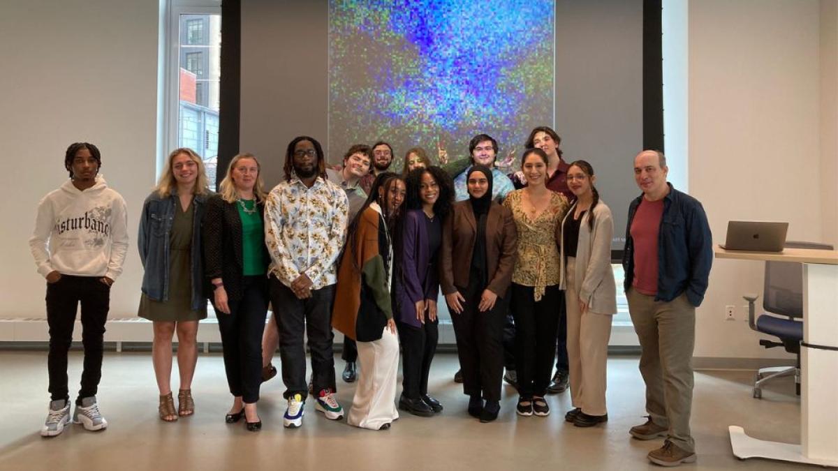 Pace Seidenberg students who interned at the 2024 AI Internship Experience Program posing for a group photo with program leads Dr. Christelle Scharff and Dr. Carmine Guida in front of an AI-generated image at the Seidenberg Design Factory.