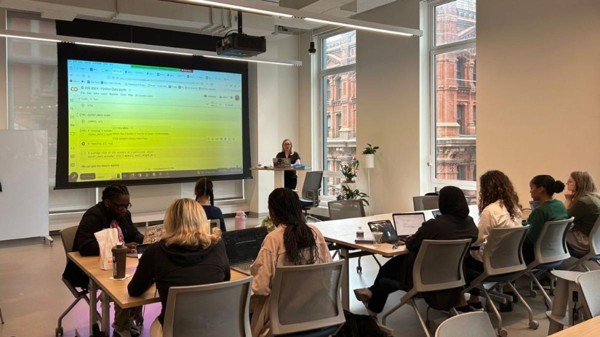 Pace Seidenberg students who are participating in the AI Internship Experience Program sitting in the NYC Design Factory, and following a Powerpoint presentation led by Seidenberg professor Dr. Christelle Scharff.
