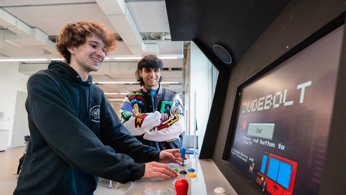 two Pace students play a game called Dudebolt at the Arcade machine