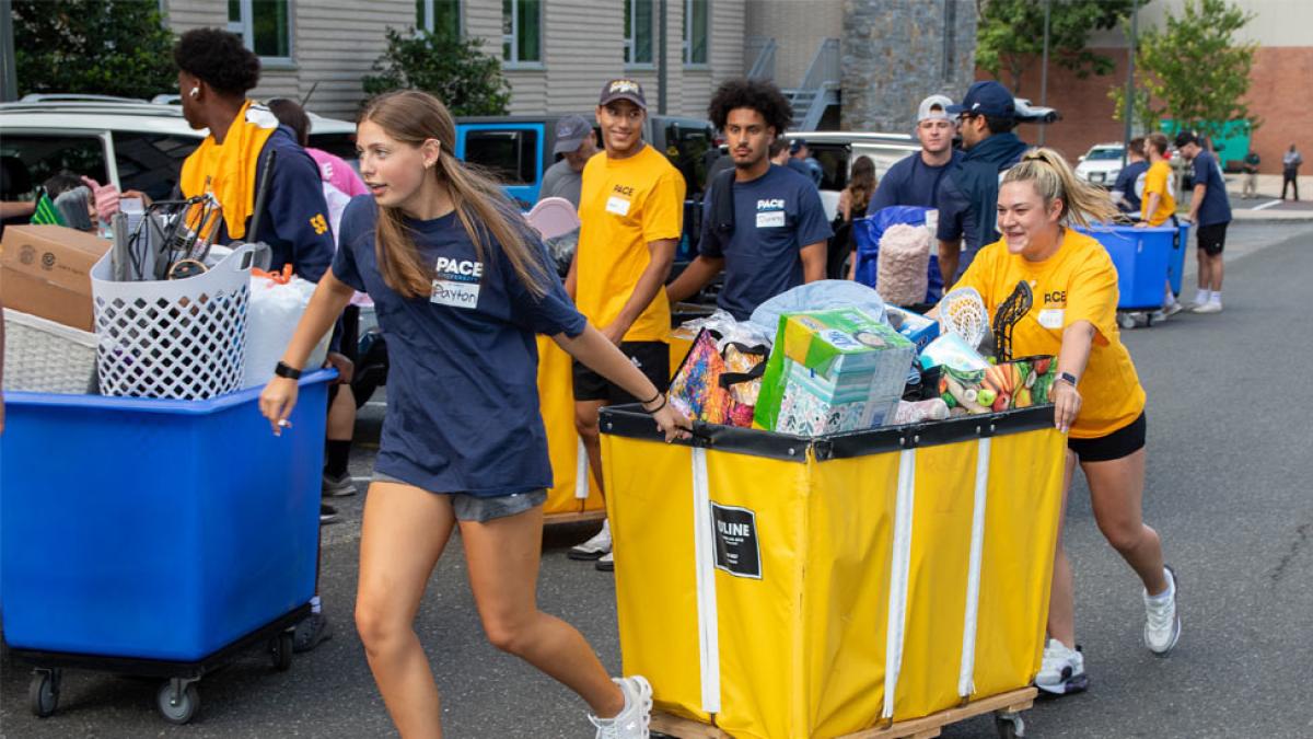 Pace students pulling bins on move-in day.