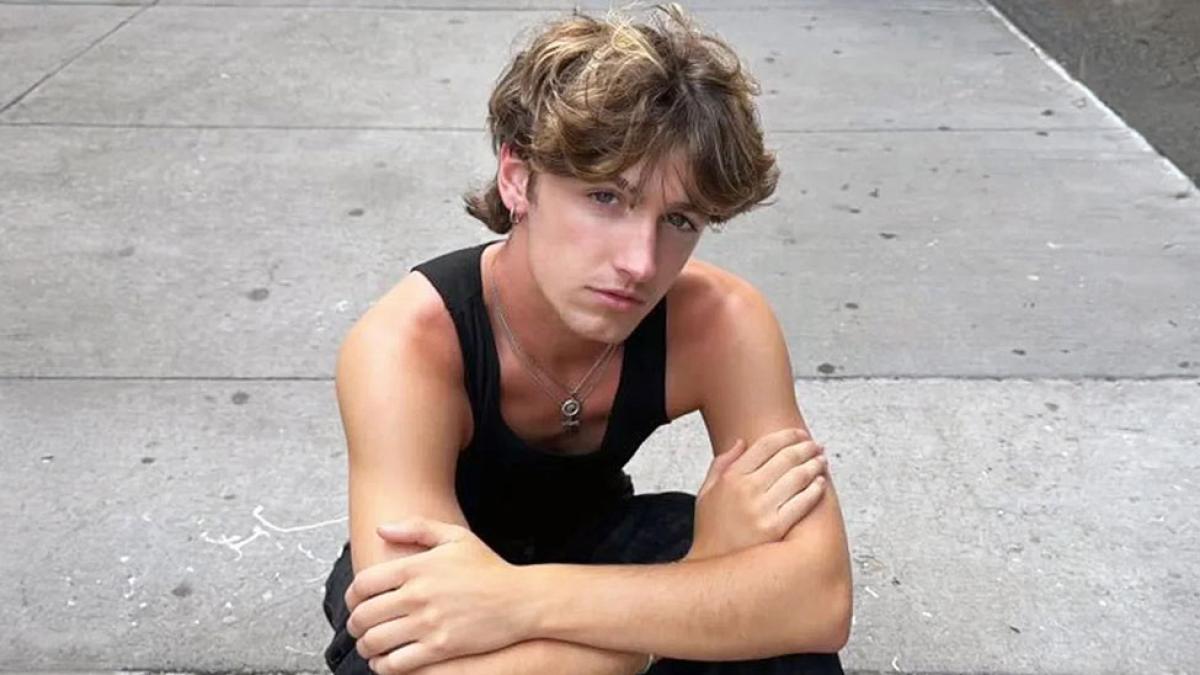 Pace University's Communication and Media Studies student Evan Smith, crouched down looking up from the pavement