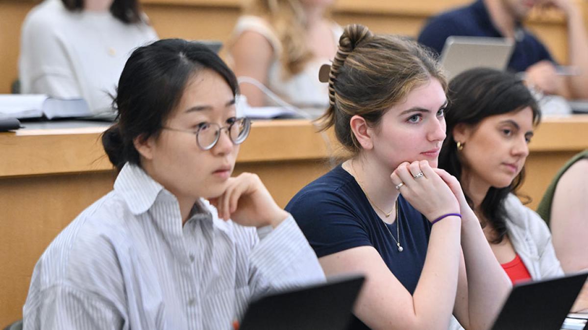 Three Elisabeth Haub School of Law students listening to a lecture.