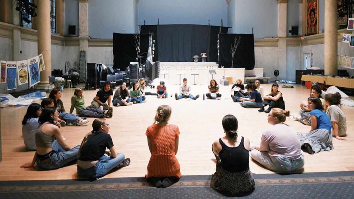 Pace University's Peace and Justice Studies and English students sitting in a circle and working with the Bread and Puppet Theater to express social justice through art.