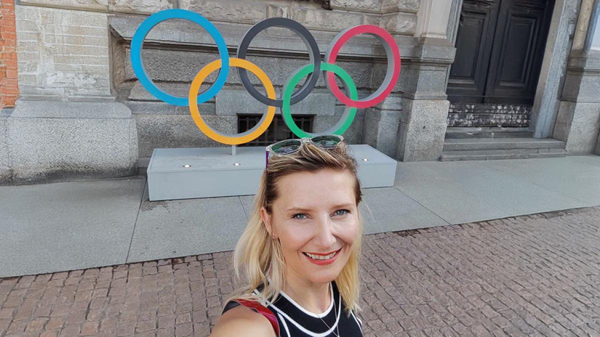 Pace University Economics professor Veronika Dolar with Olympic rings in the background.