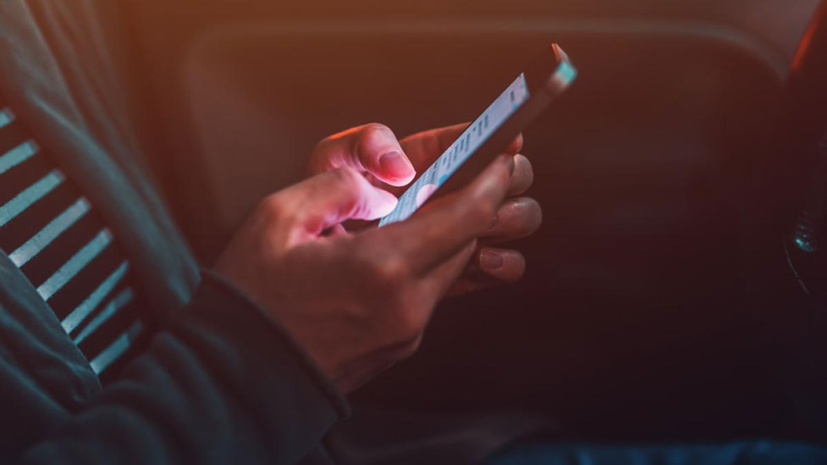 A person texting on a phone in a car