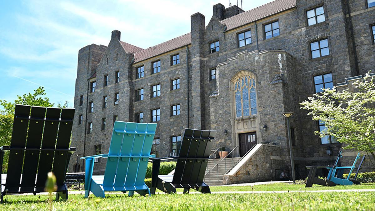 Photo of Preston Hall  and two lawn chairs at the Elisabeth Haub School of Law.