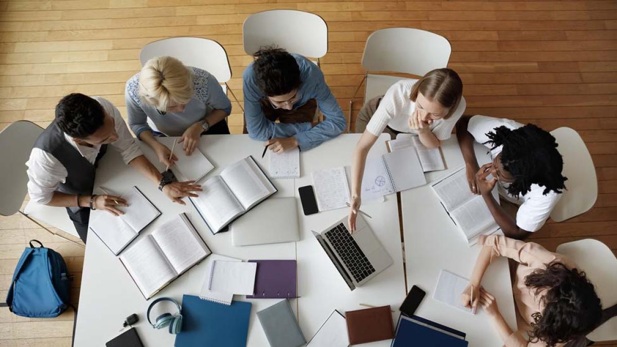 Students gathering around a table working on a group project