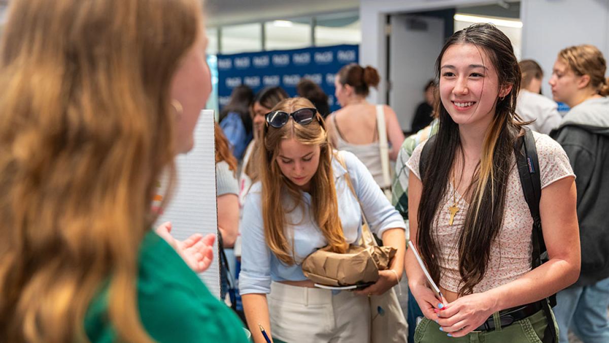 Pace University students speaking with others at student activities fair