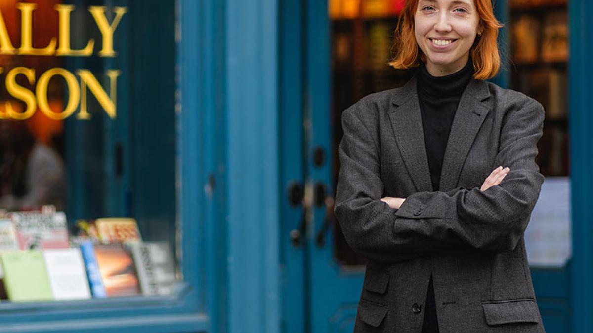 A Pace University publishing student stands outside of a book store.