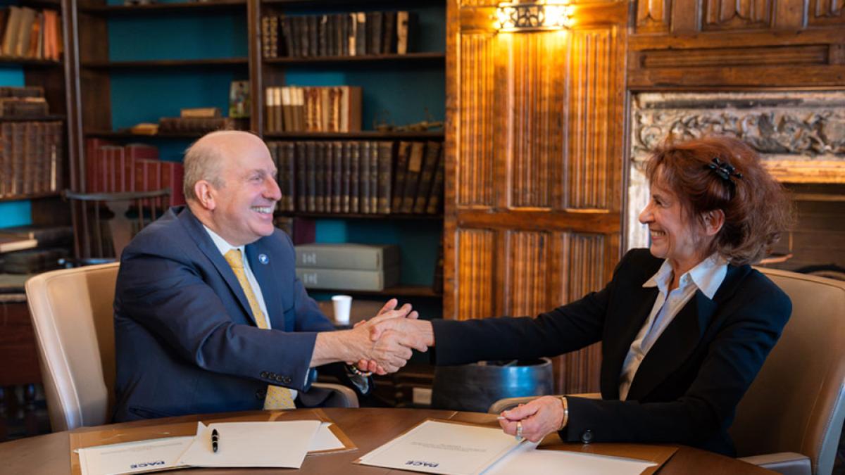 President Marvin Krislov and Gale Epstein shaking hands in the Pace Study. 