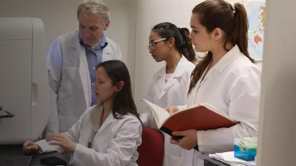 Pace professor Nigel Yarlett works with Pace students in a research lab