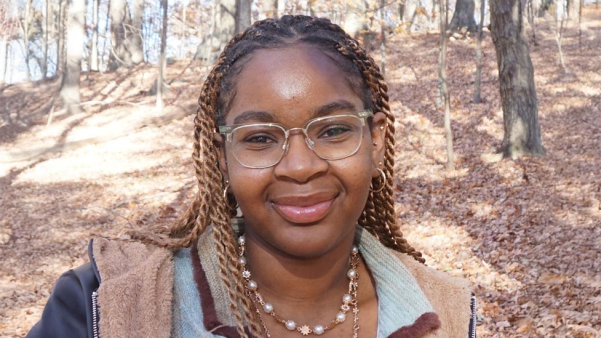 Pace University Economics student Shaniah James with leaves behind her